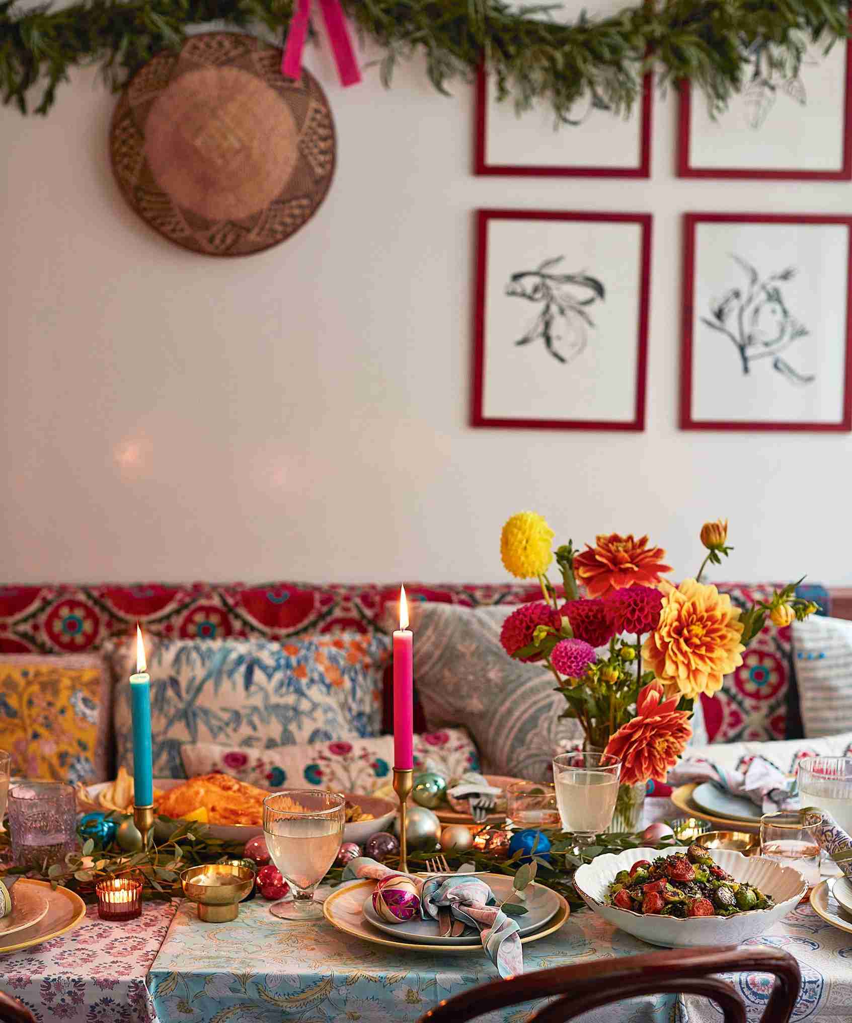Colorful Christmas dining table with varied candles and floral details.