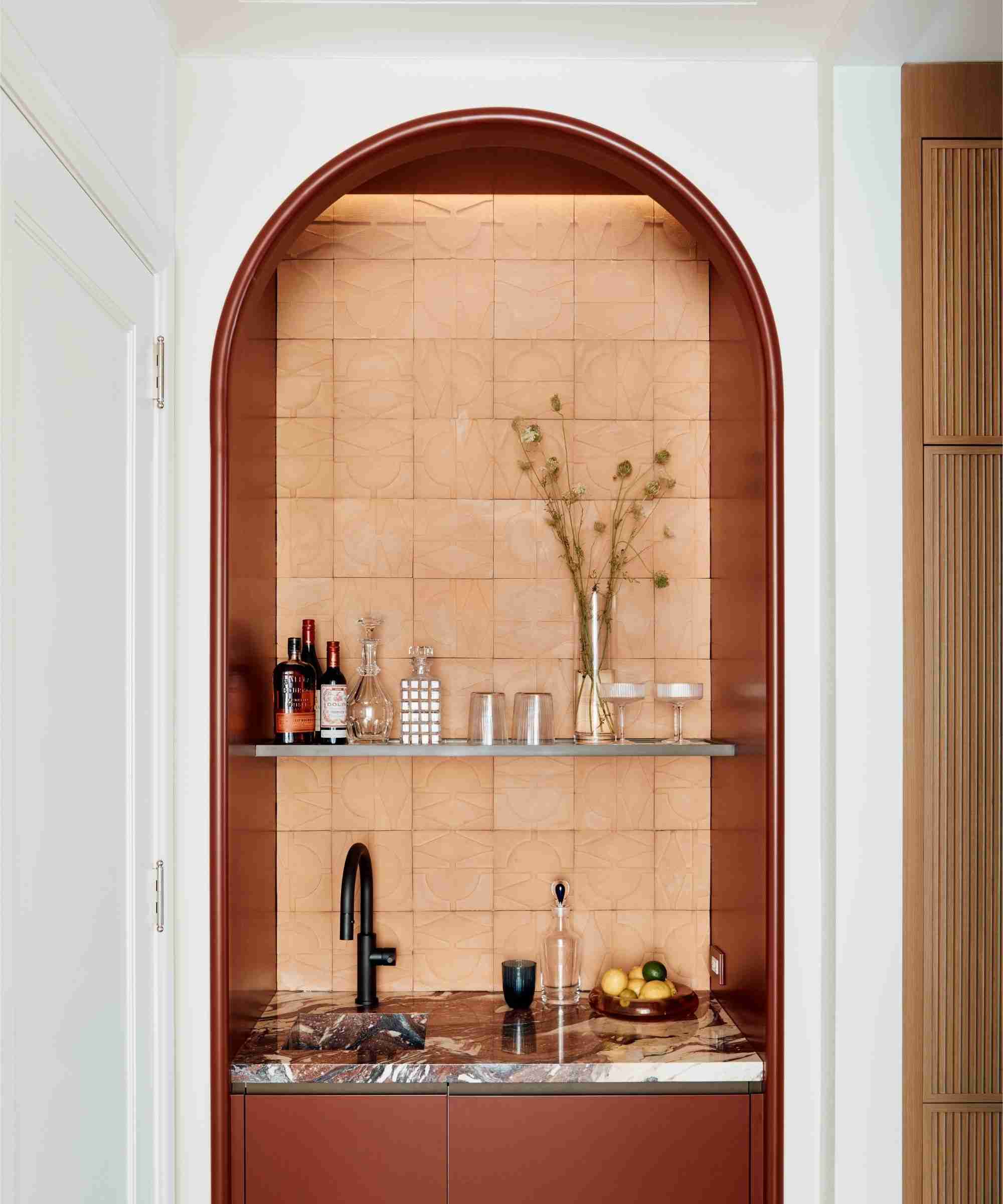 Small home bar set within an arched alcove in the featured Manhattan apartment.